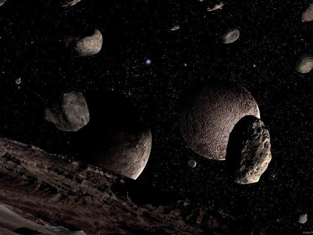 Gefährliches Terrain. Das Kuiper-Objekt Xena und sein Mond Gabrielle passieren eine Asteroidenfamilie.
