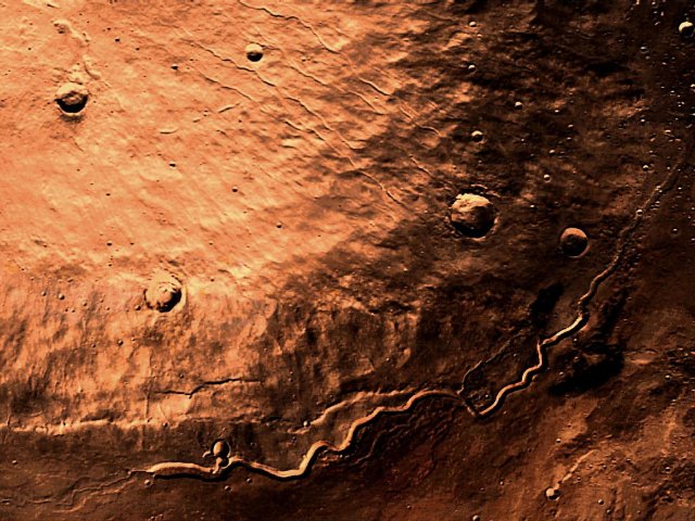 Sonnenaufgang am Buvinda Vallis auf der Elysium Planitia. Der 7 km hohe und 180 km durchmessende Hecates Tholus steht bereits im vollen Sonnenlicht.